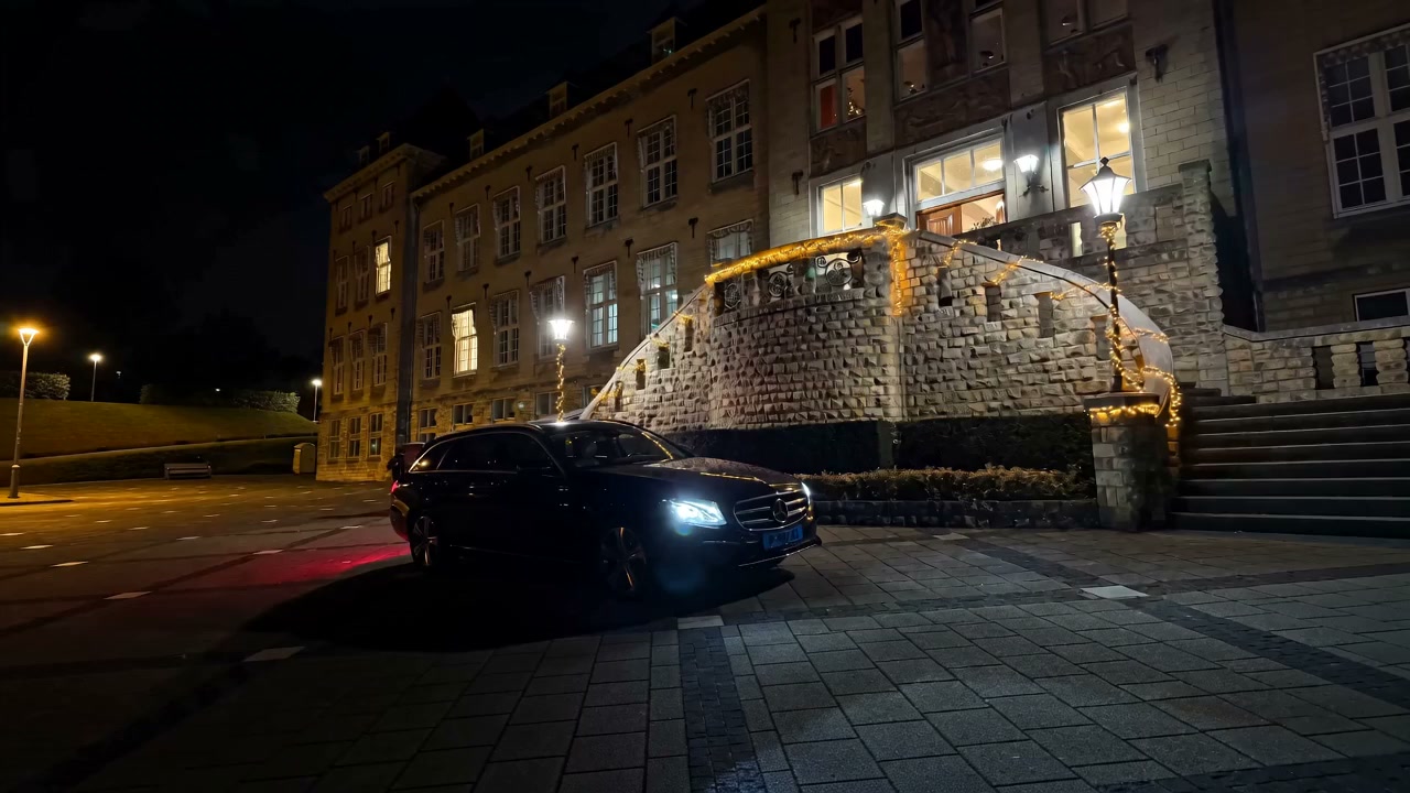 Zwarte Mercedes E-Klasse van Taxi-Privé bij avond voor een verlicht monumentaal pand